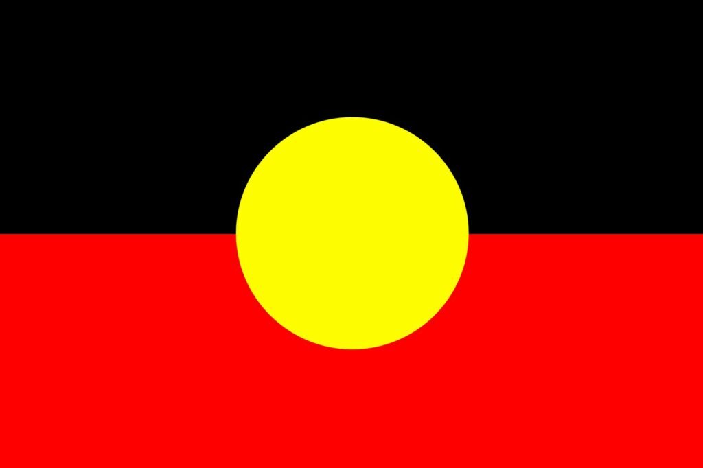 Australian Aboriginal flag with black and red horizontal sections and a yellow circle in the centre.
